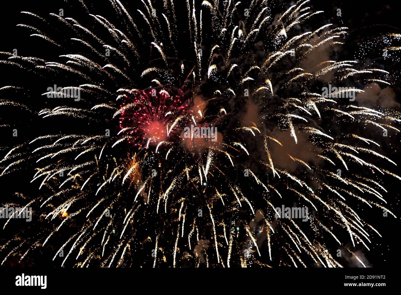 Looking up at fireworks exploding against a night sky Stock Photo