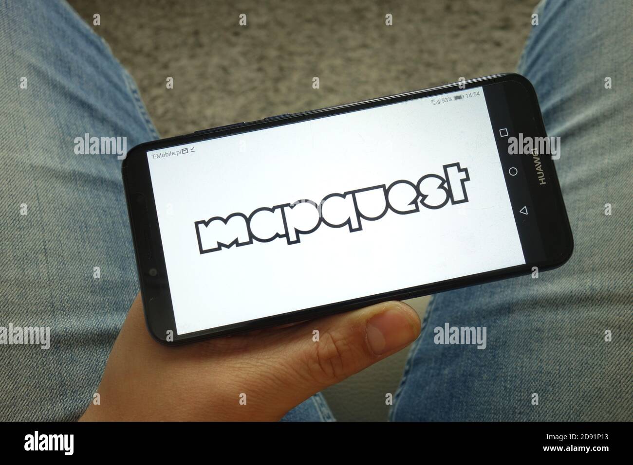 Man holding smartphone with MapQuest - Man Holding Smartphone With Mapquest Web Mapping Service Logo 2D91P13 