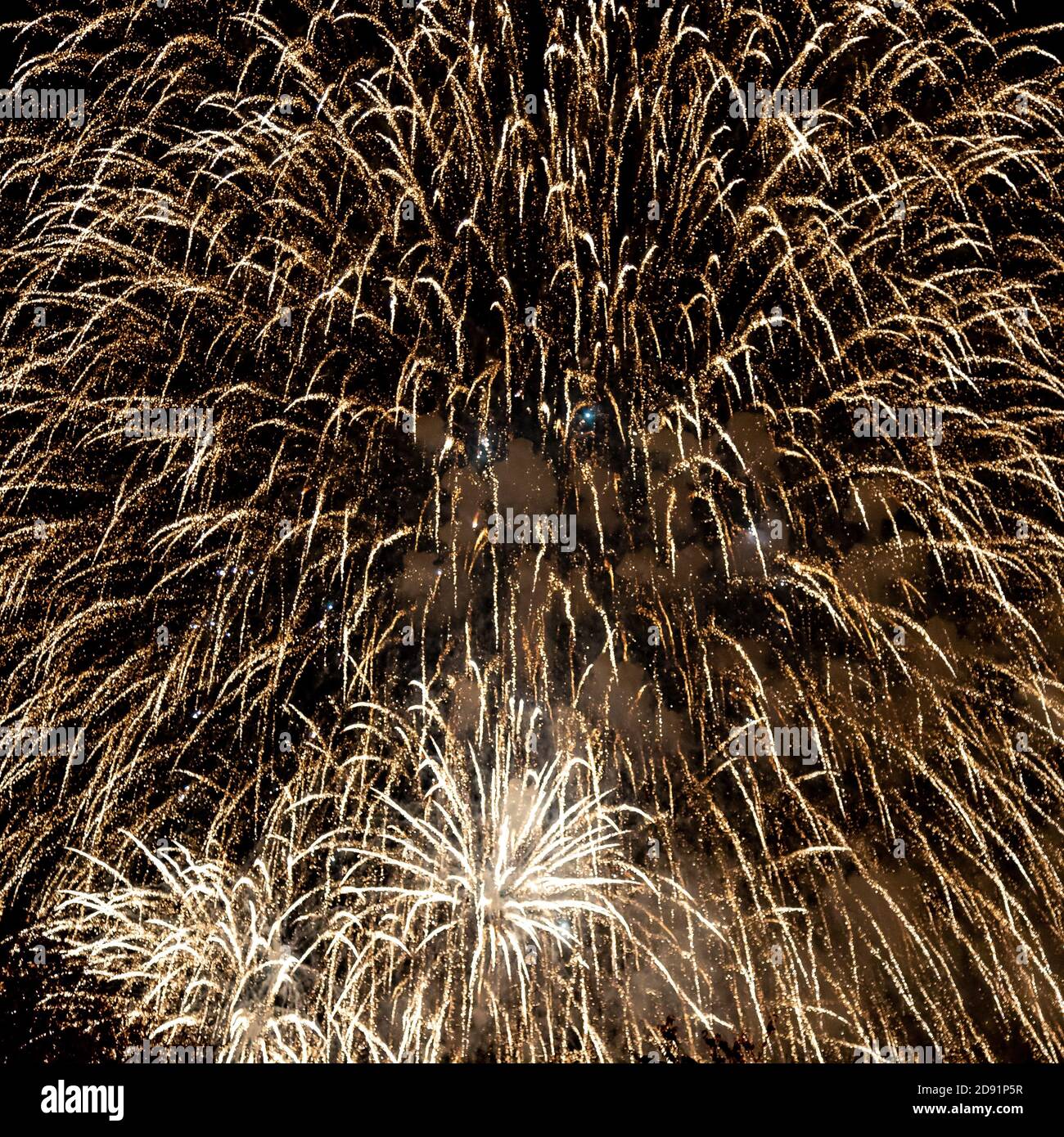 Looking up at fireworks exploding against a night sky Stock Photo