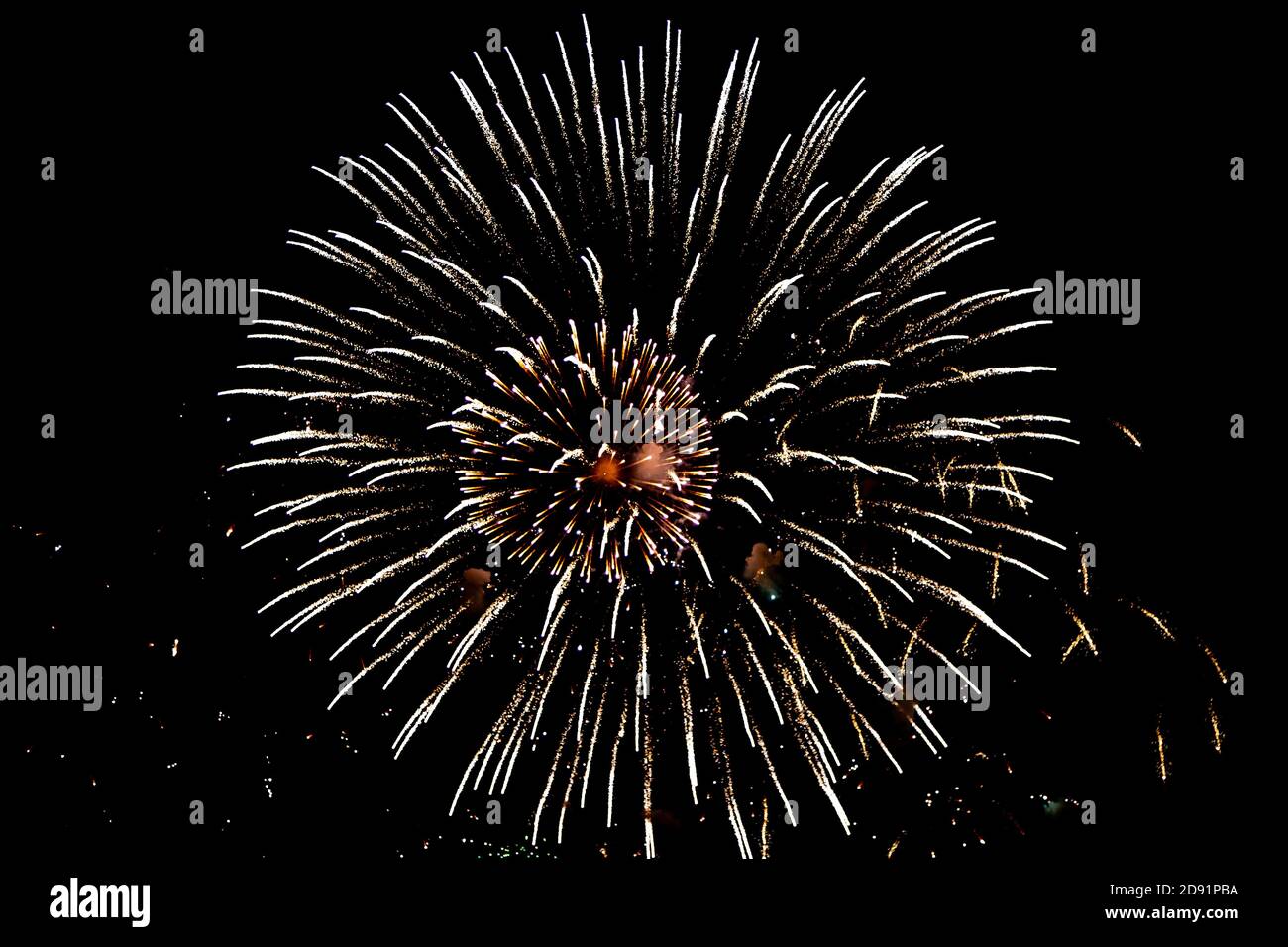 Looking up at fireworks exploding against a night sky Stock Photo