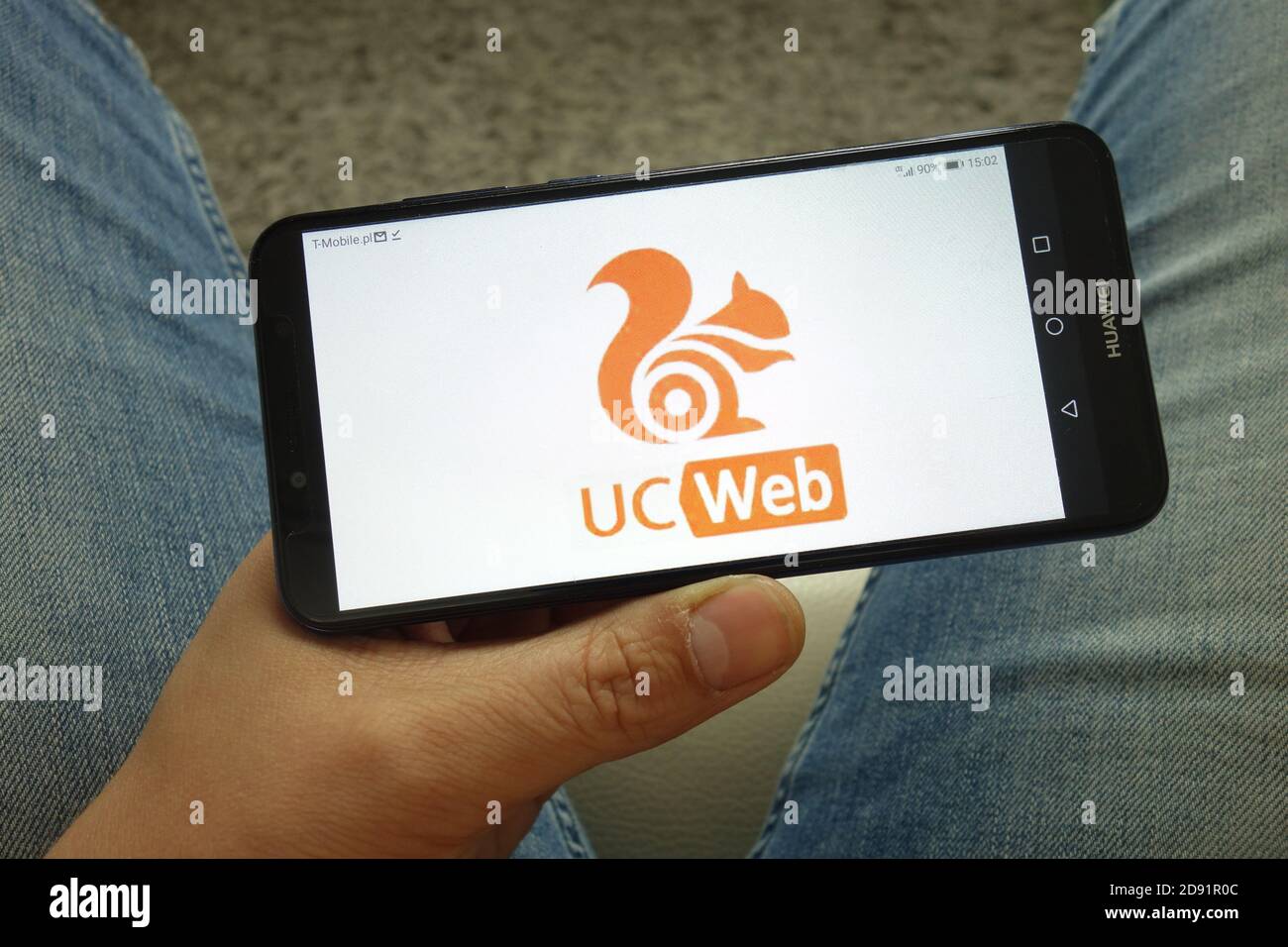 Man holding smartphone with UCWeb Inc Chinese mobile internet company logo Stock Photo