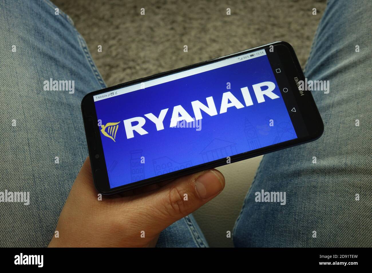 Man holding smartphone with Ryanair airline logo Stock Photo