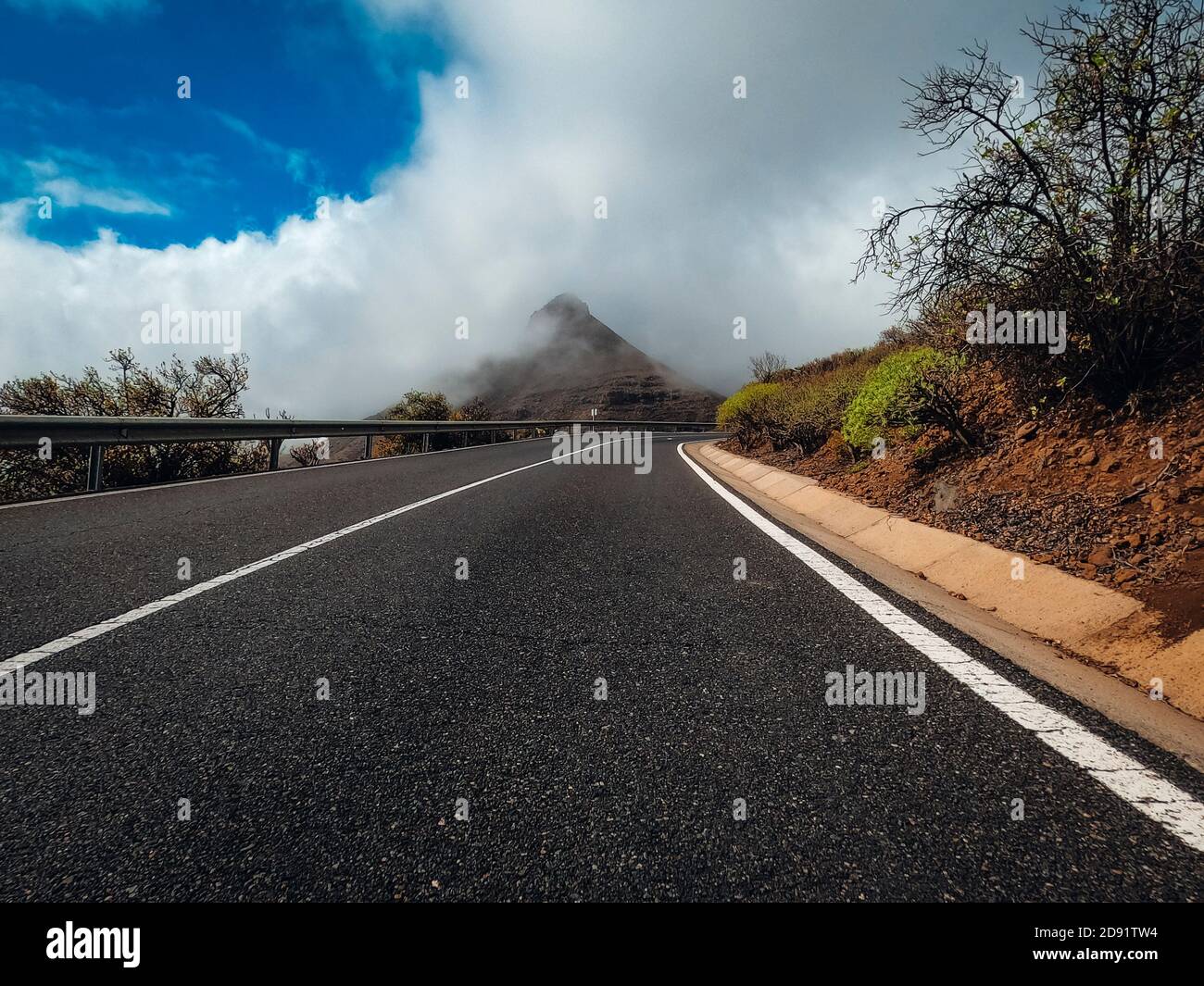 Long asphalt road ground view and travel concept - mountain and sky landscape - outdoor road trip in scenic place background Stock Photo