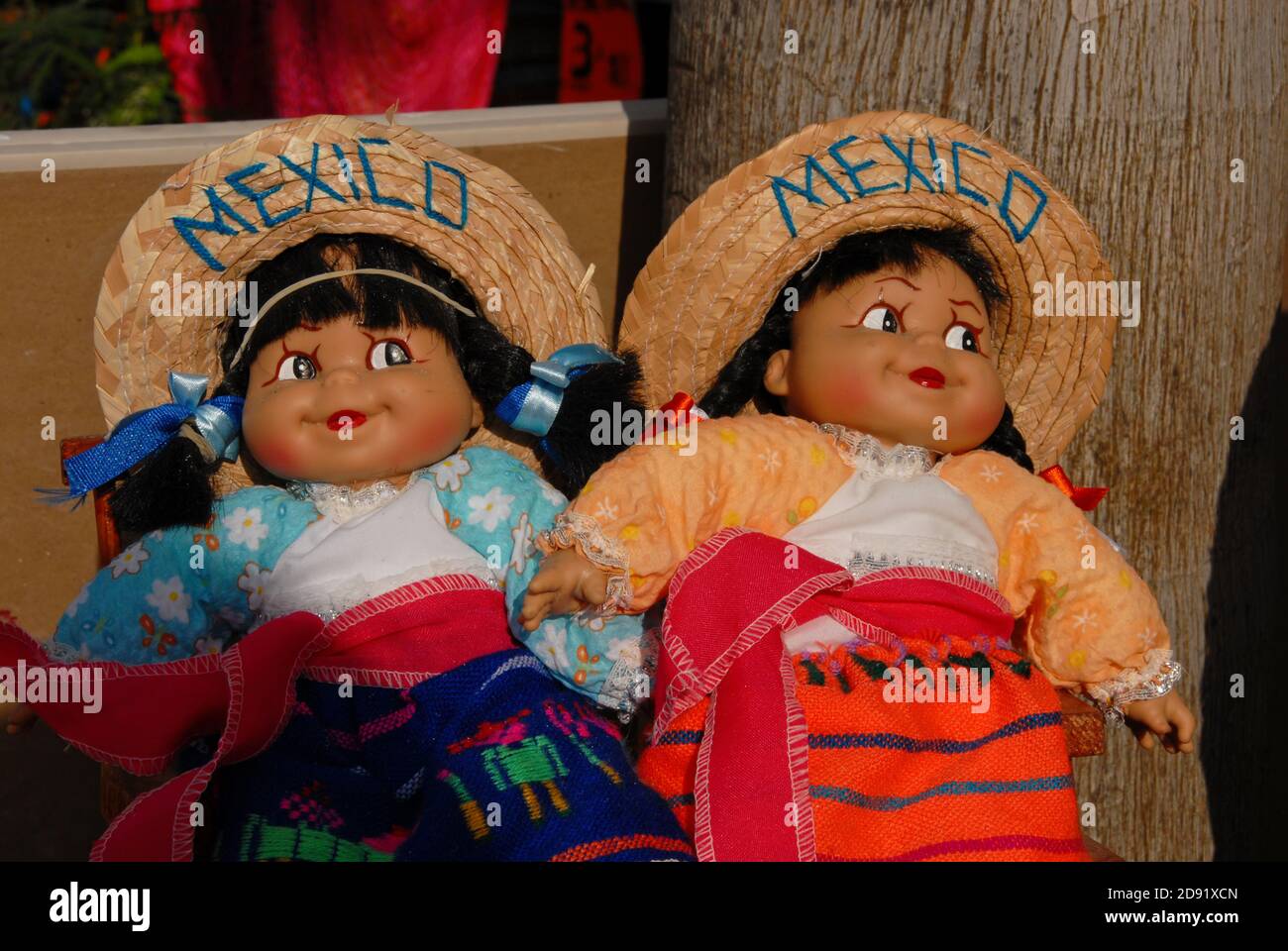 Two Female dolls in colorful traditional clothes of Mexican people , sombrero with the Mexico inscription. Stock Photo