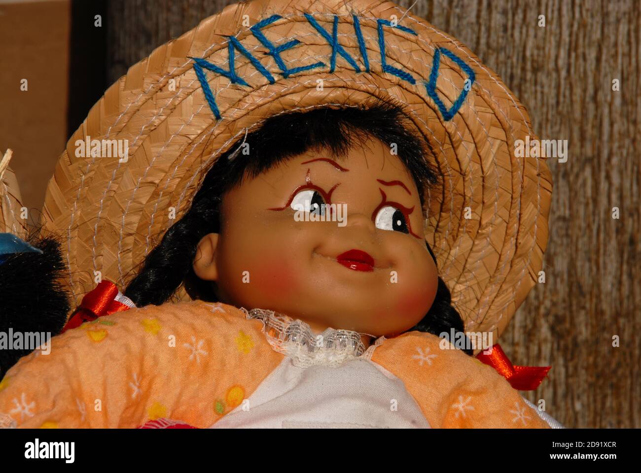 Female doll in colorful traditional clothes of Mexican people , sombrero with the Mexico inscription. Stock Photo