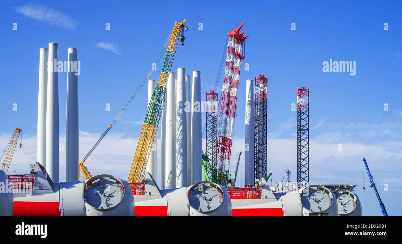 Wind turbine nacelles with rotor hubs and tower sections for offshore SeaMade wind farm at REBO heavy load terminal in Ostend port, Flanders, Belgium Stock Photo