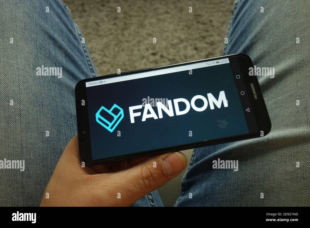 Man holding smartphone with Fandom website logo Stock Photo