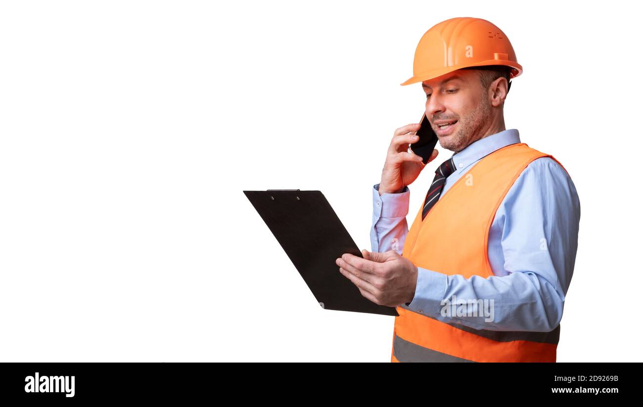 Builder In Uniform Talking On Phone Standing On White Background Stock Photo