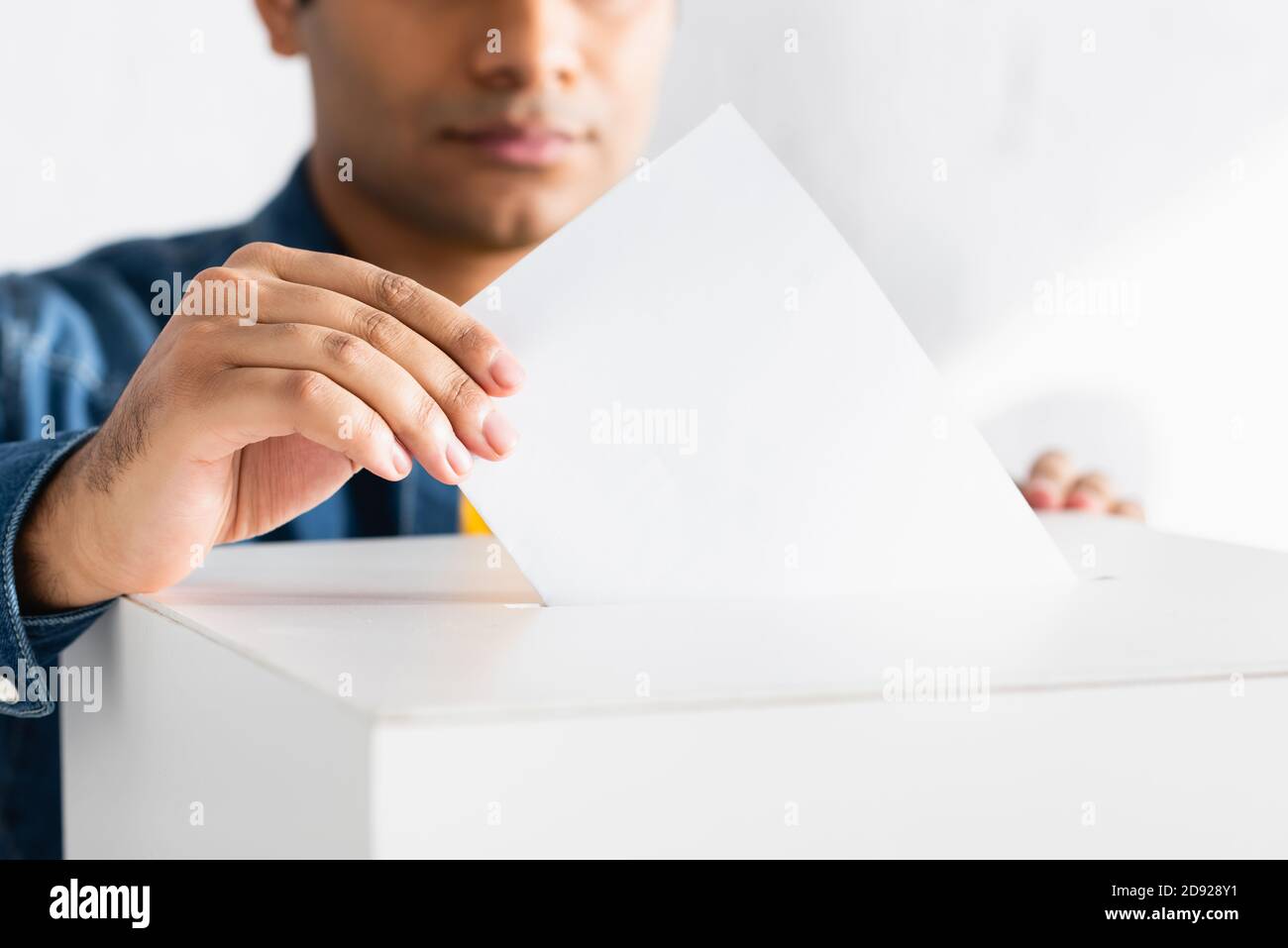 cropped view of indian man inserting ballot into polling booth Stock Photo