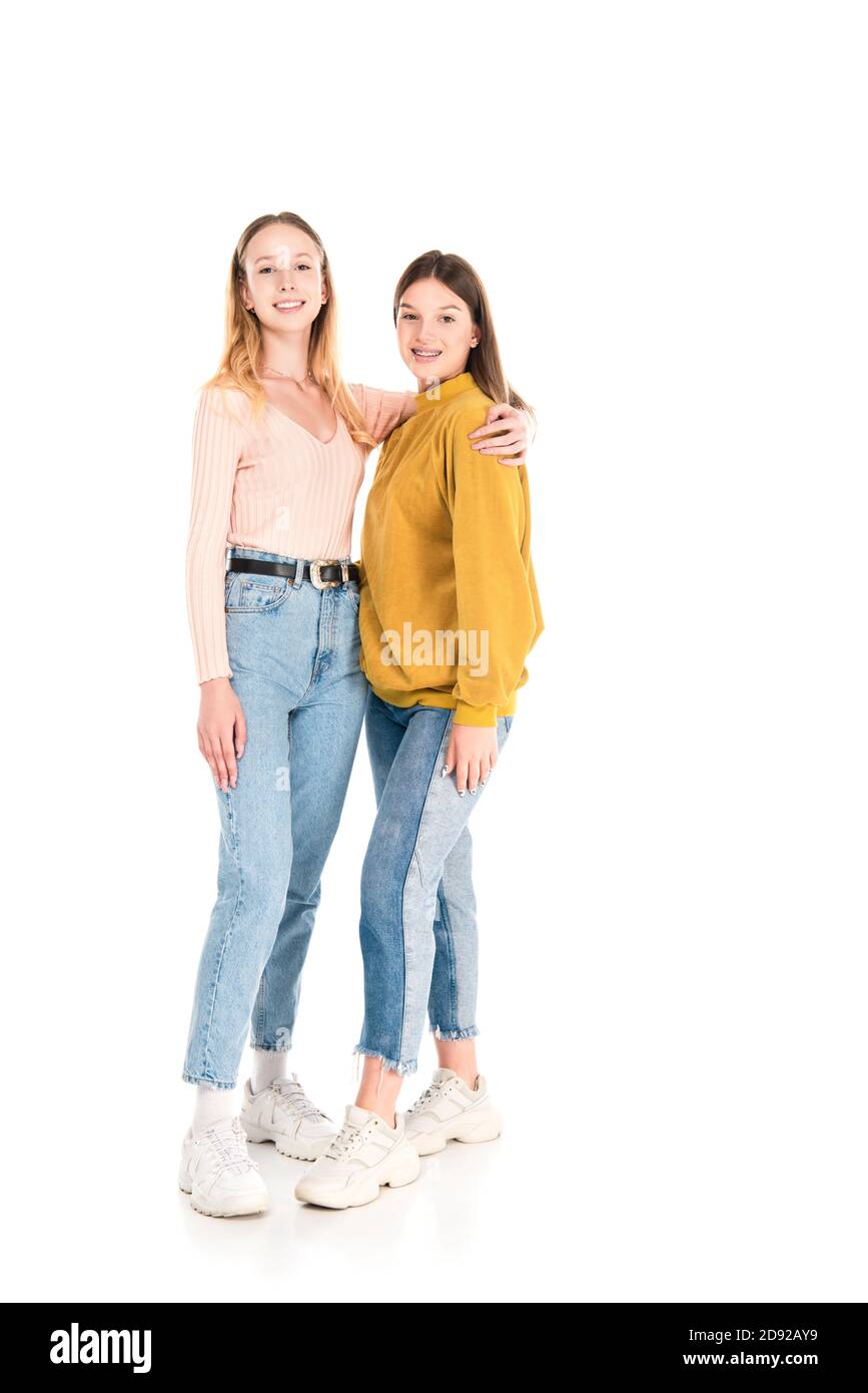 Smiling teen girls embracing and looking at camera on white background Stock Photo