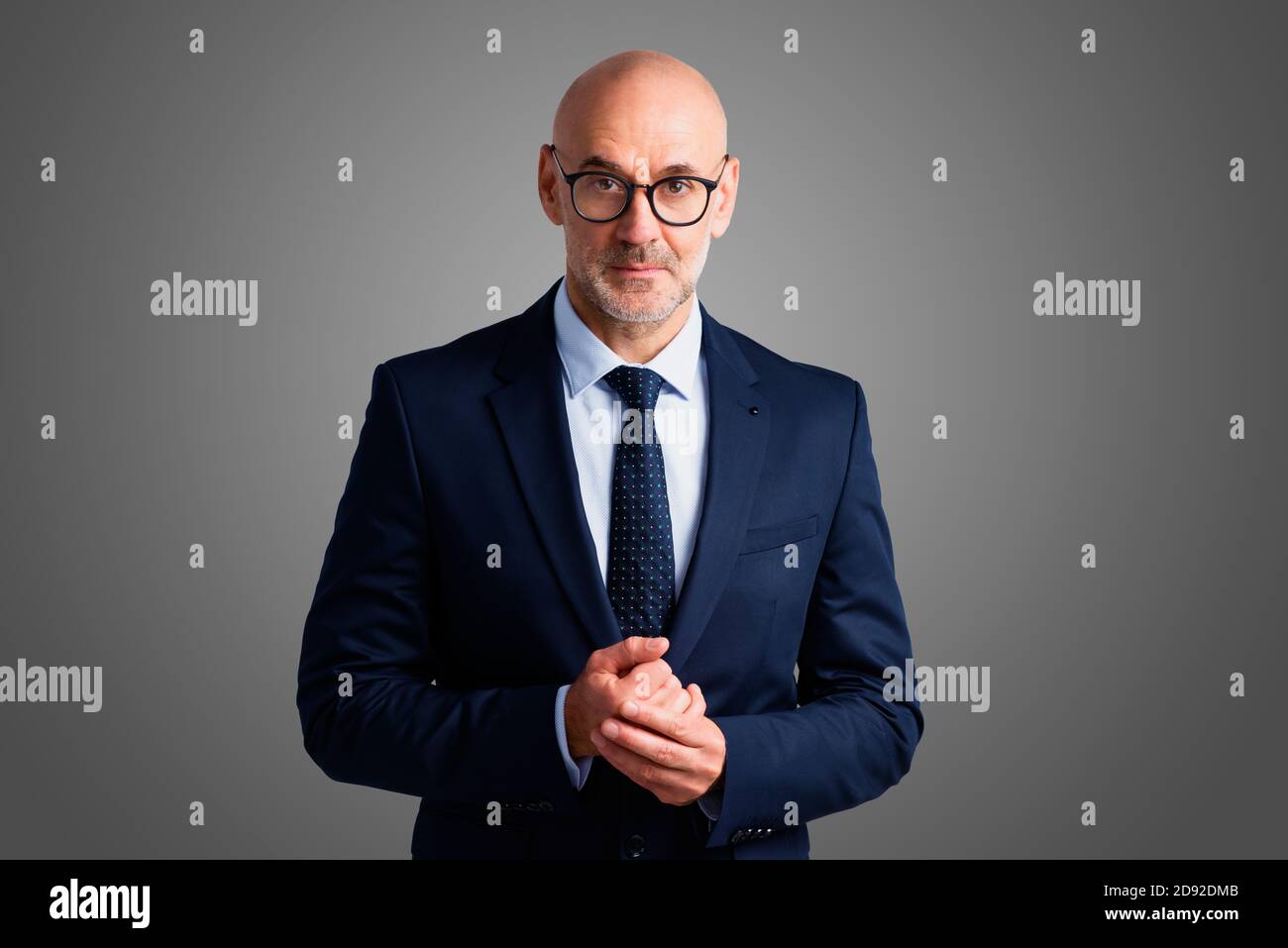Studio portrait of confident businessman wearing suit while standing at ...