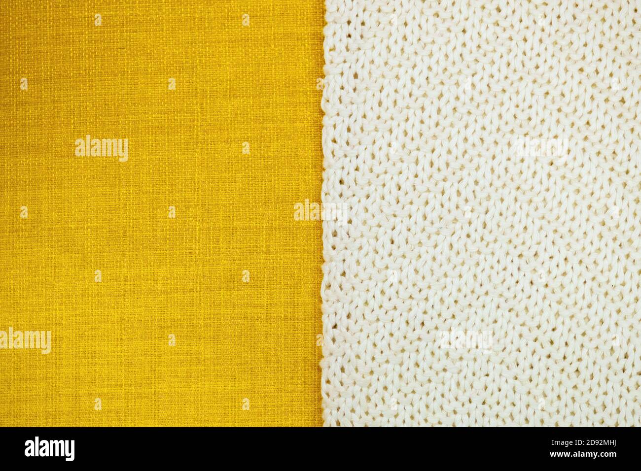 background from two part yellow textile and white knitting cloth, copy space. Stock Photo