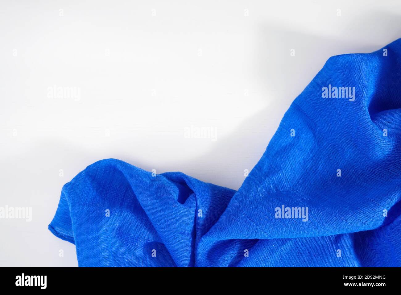 Crumpled blue fabric on white background. Copy space for text Stock Photo