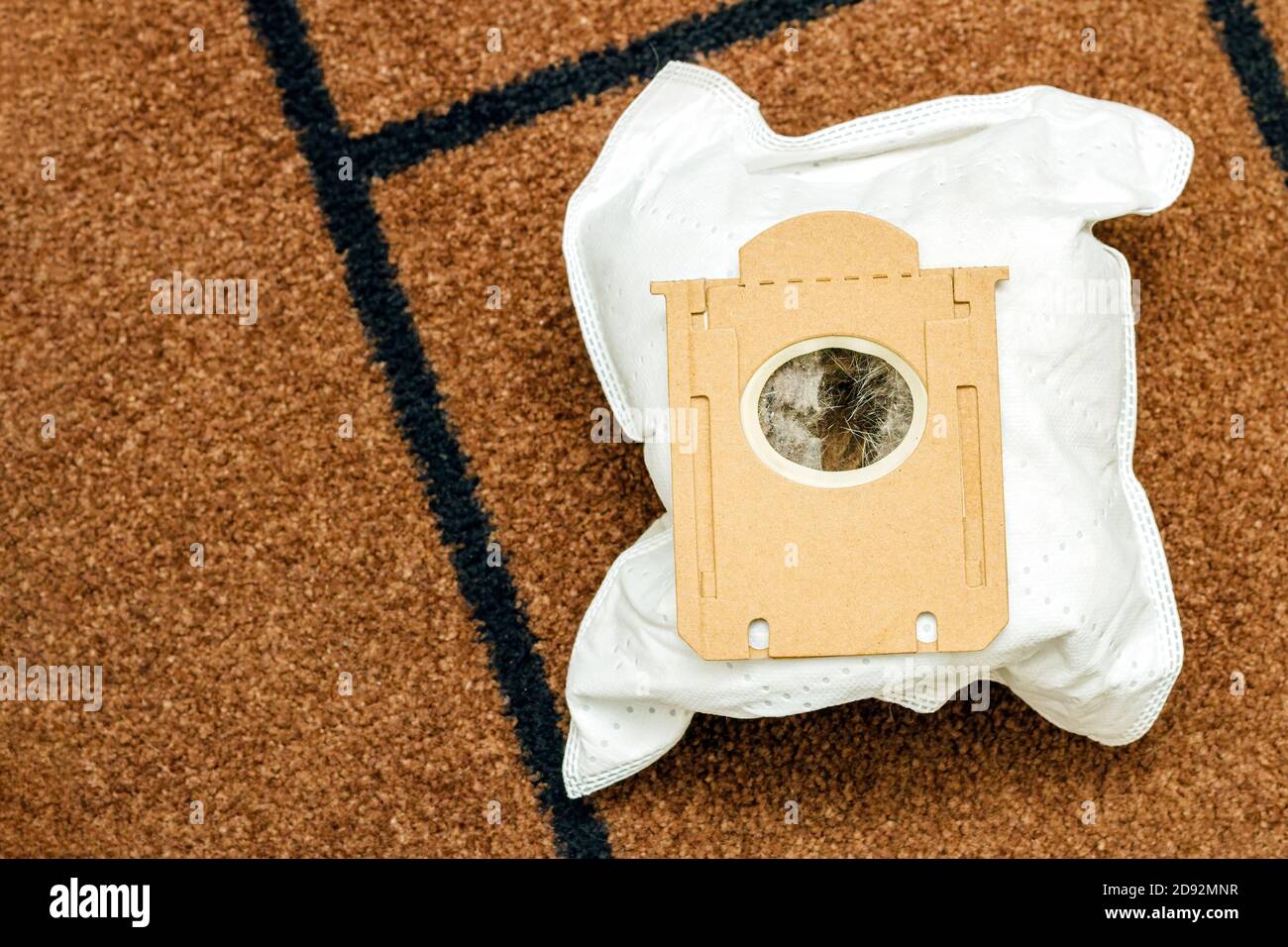 vacuum cleaner bag filled dust and animal hair on brown mat background, copy space, top view Stock Photo
