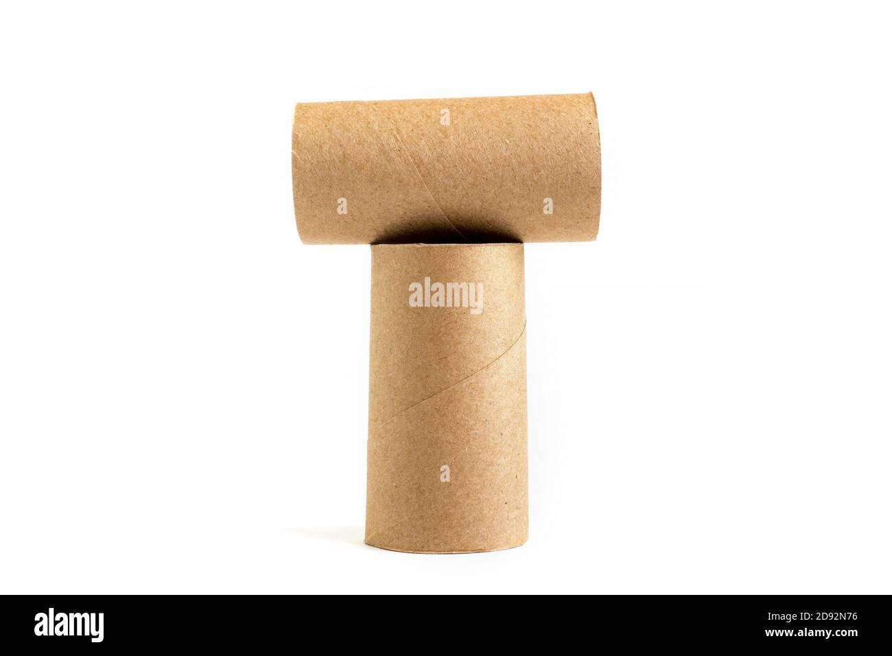 Letter T from composition of two cardboard paper tubes on white background. Close-up of empty toilet rolls Stock Photo