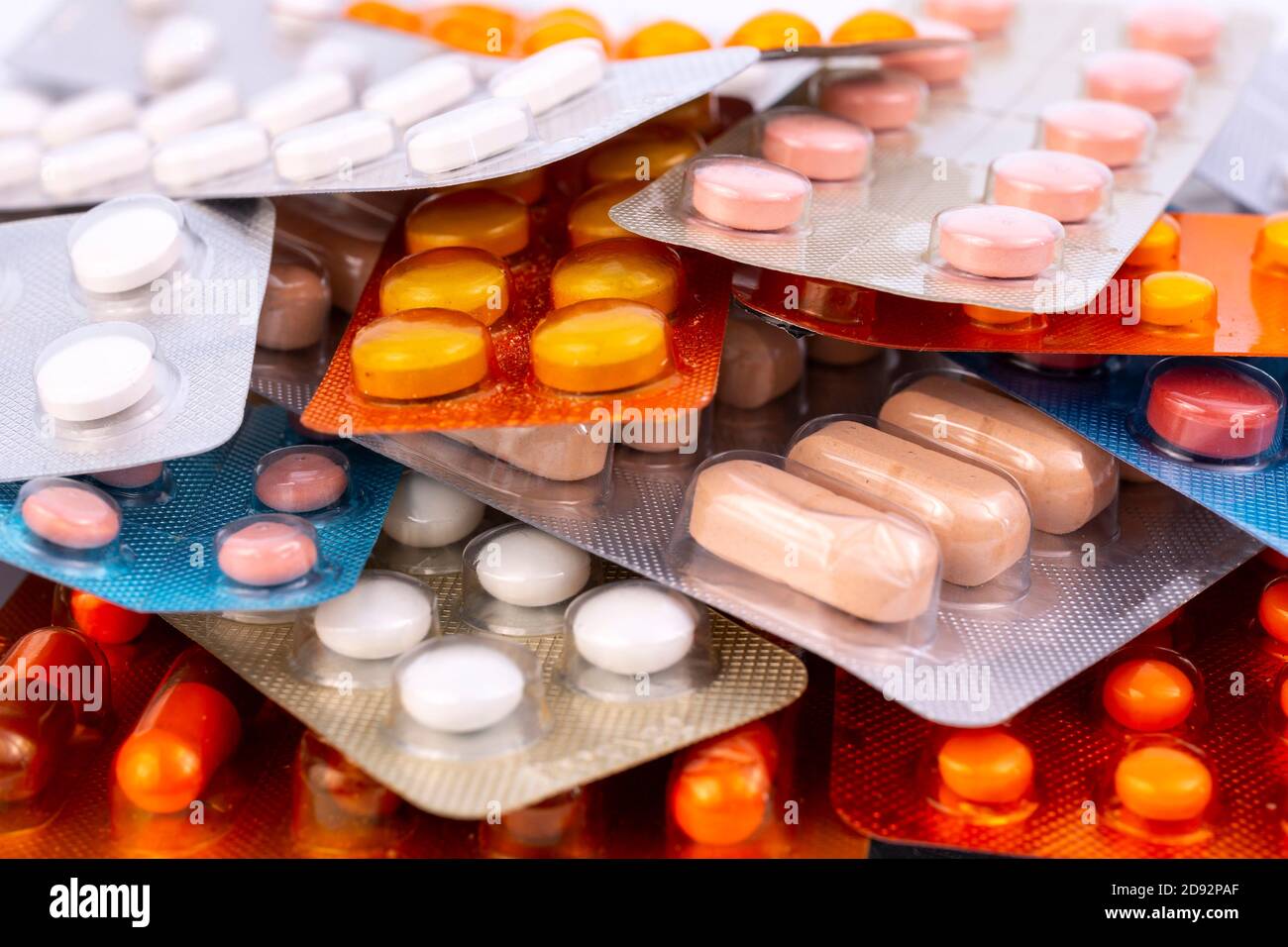Different colorful capsules and pills in plastic packs - blisters stacked. Global pharmaceutical industry for billions dollars per year. Pharmaceutica Stock Photo