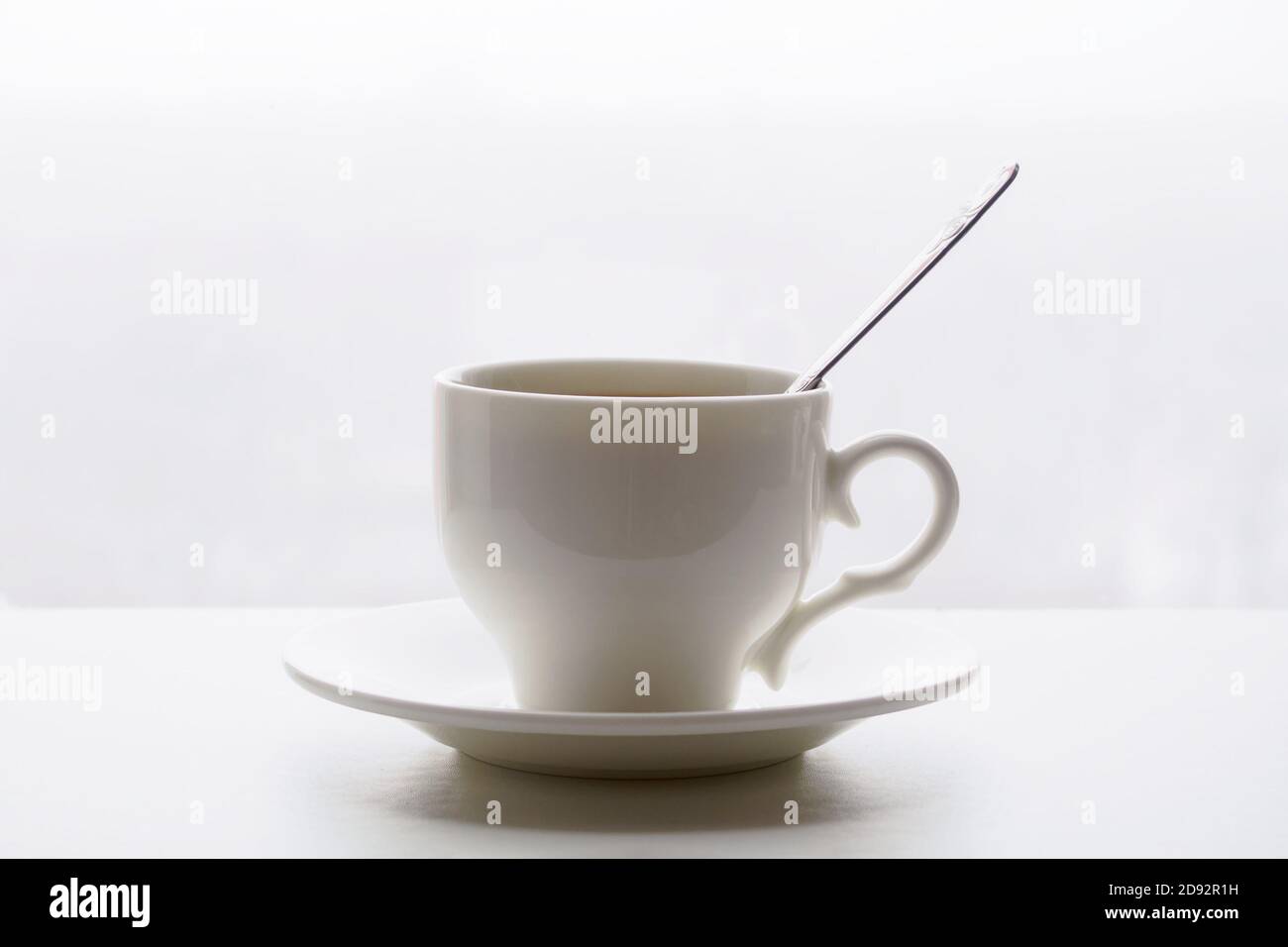 white cup with spoon and saucer on white background Stock Photo