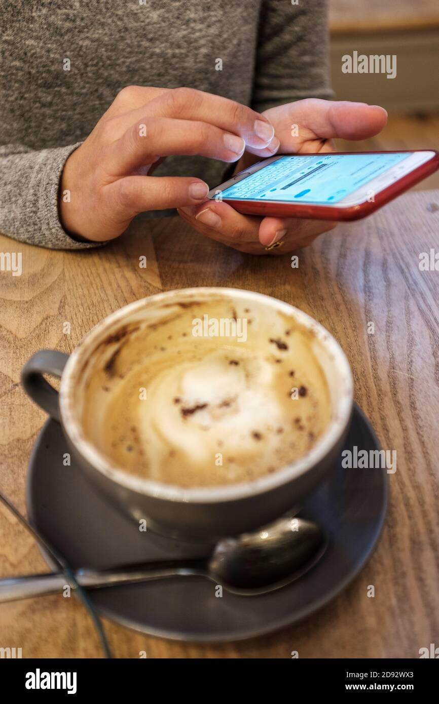 Woman on teting on her phone in coffee shop,London,UK Stock Photo