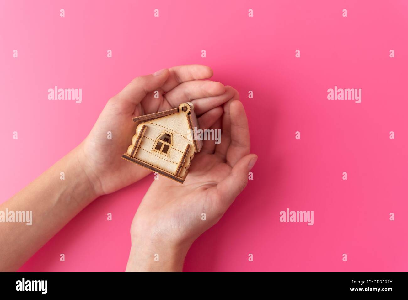 Woman with toy wooden house and template for design on pink Stock Photo