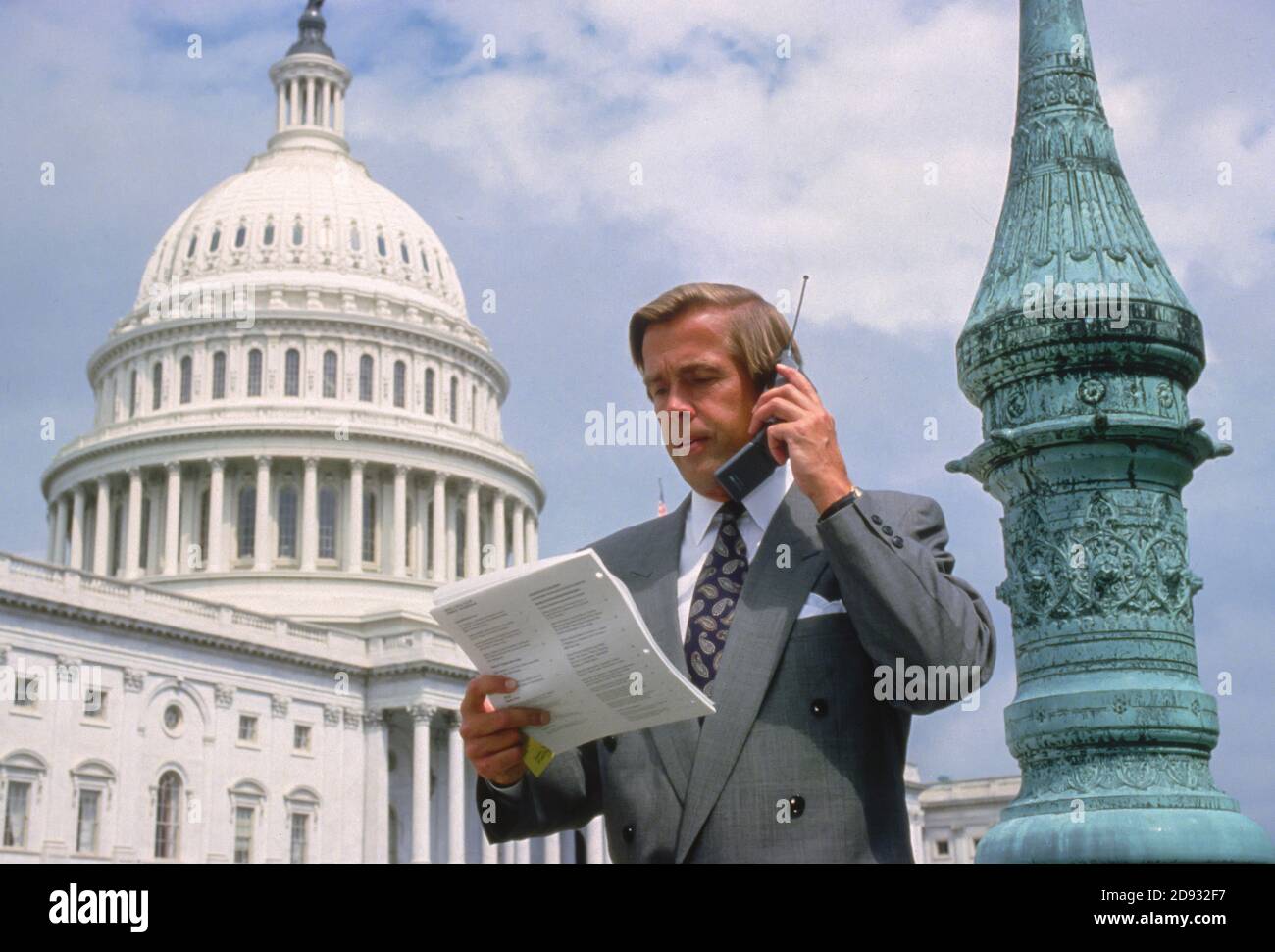 WASHINGTON, DC, USA - Healthcare lobbyist on cell phone in front of U.S. Capitol building. Stock Photo
