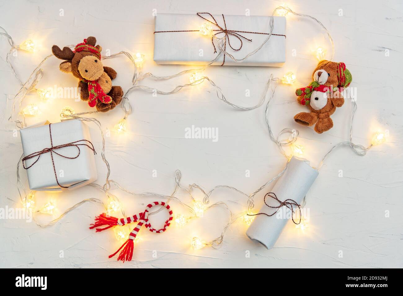 Glowing fairy lights gift boxes and toy animals on white Stock Photo