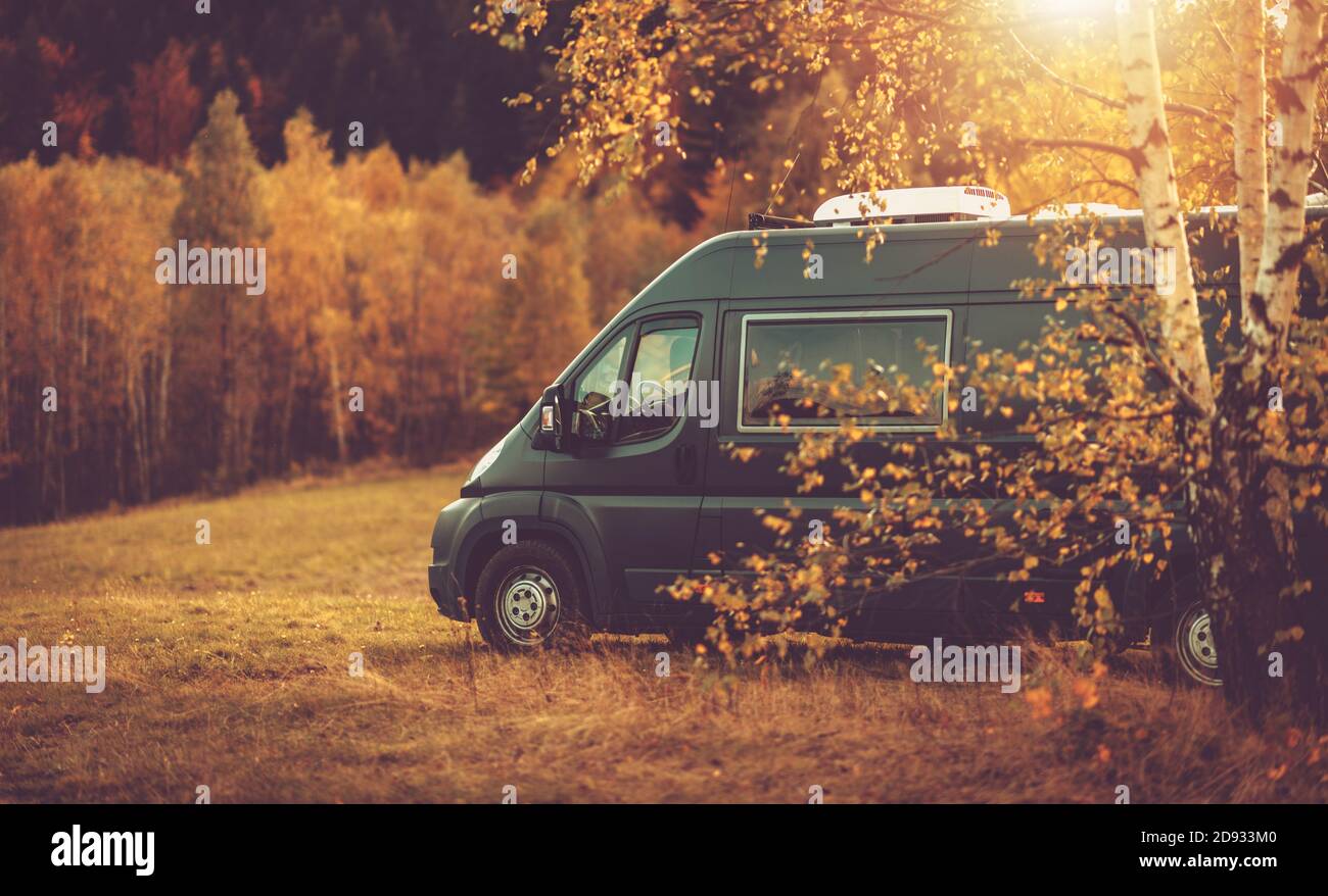 Autumn Fall Foliage RV Recreational Vehicle Camper Van Road Trip and Scenic Camping in Beautiful Place. Motorhome and the Scenic Nature. Travel Theme. Stock Photo