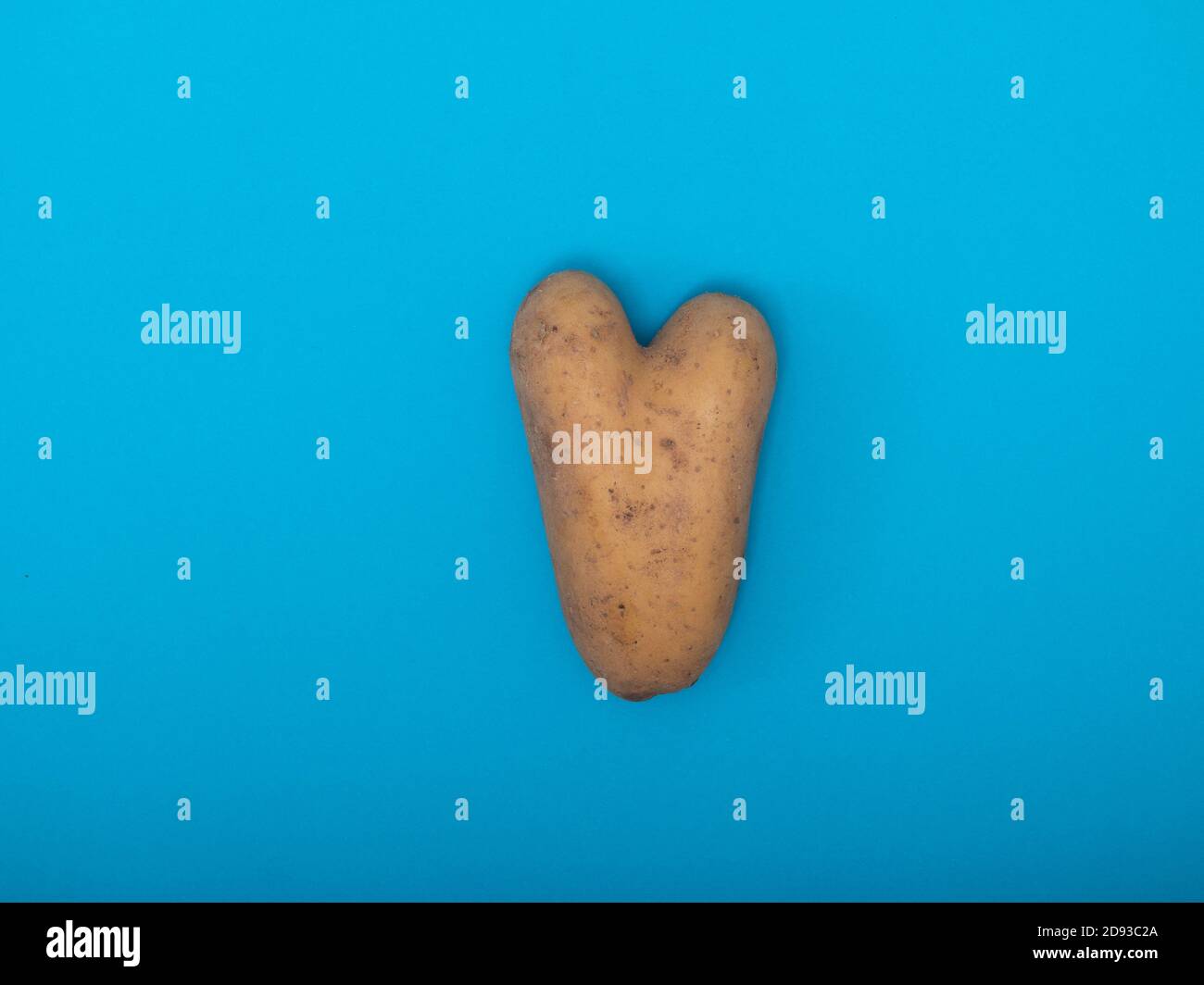 potatoes in the form of heart on a blue background Stock Photo