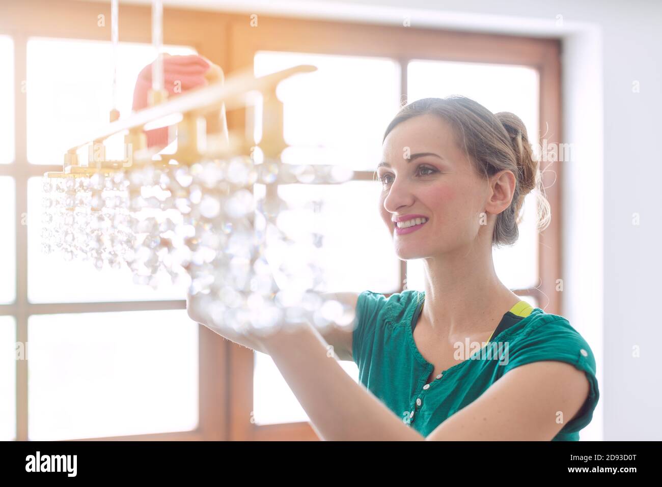 Woman dusting a lamp during spring cleaning Stock Photo