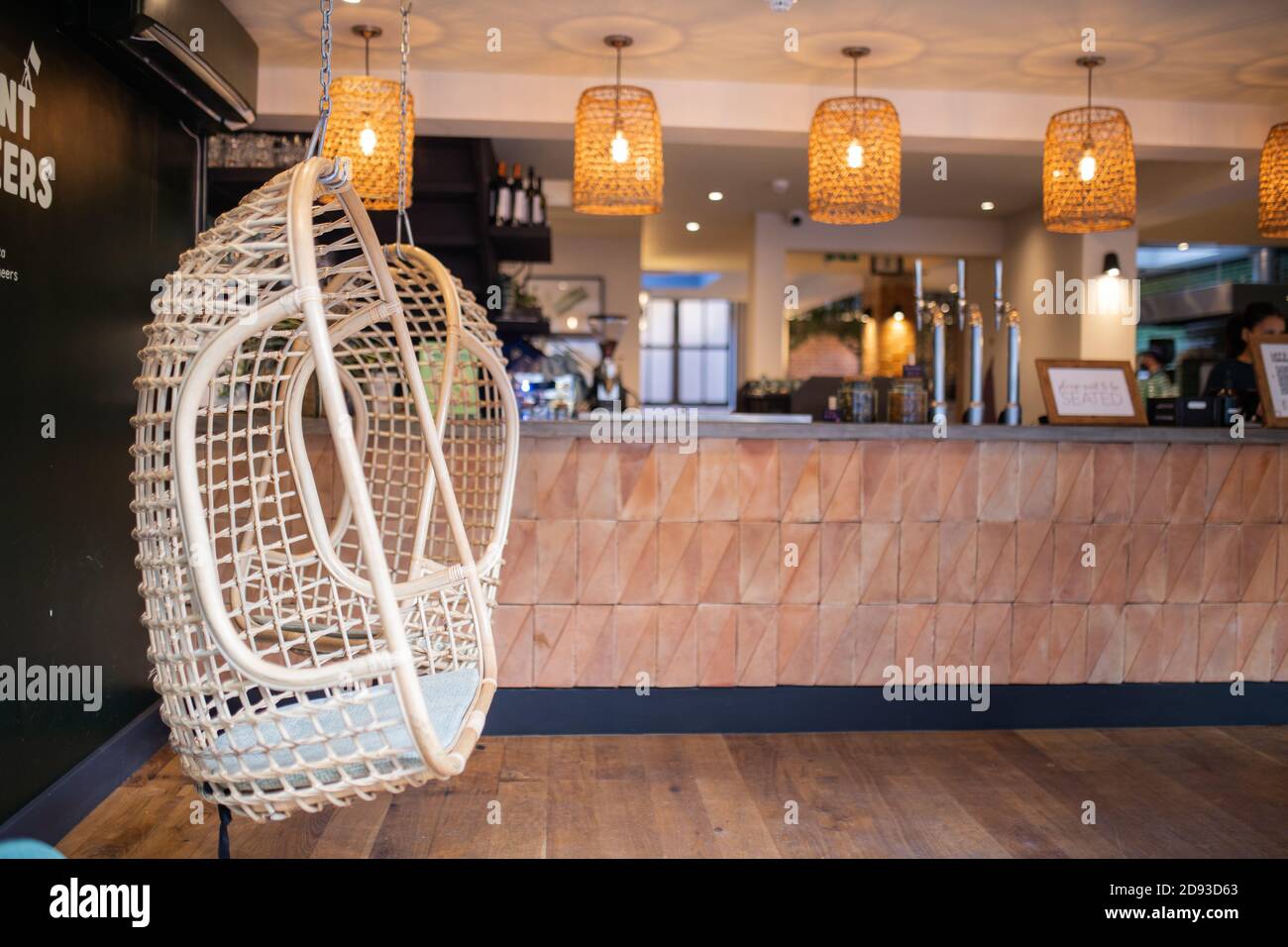 Handcrafted swings hanging next to the wooden counter of a vegan restaurant Stock Photo