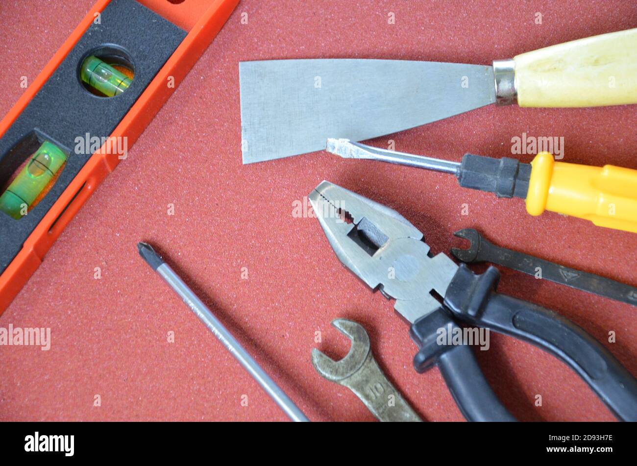 Top view of Working tools,wrench,socket wrench,hammer,screwdriver,plier,electric drill,tape measure,machinist square on wooden board. flat lay design. Stock Photo