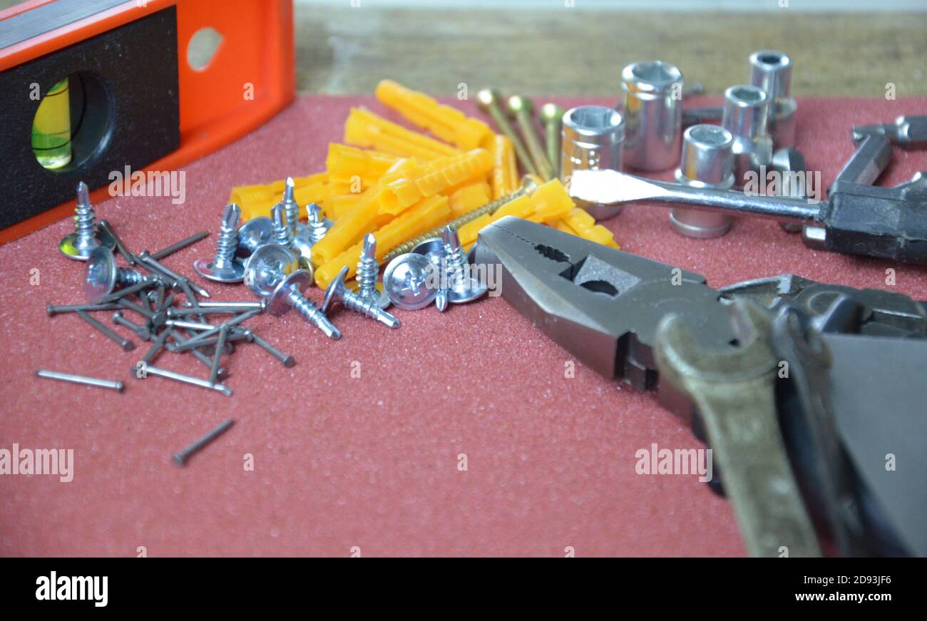 Top view of Working tools,wrench,socket wrench,hammer,screwdriver,plier,electric drill,tape measure,machinist square on wooden board. flat lay design. Stock Photo