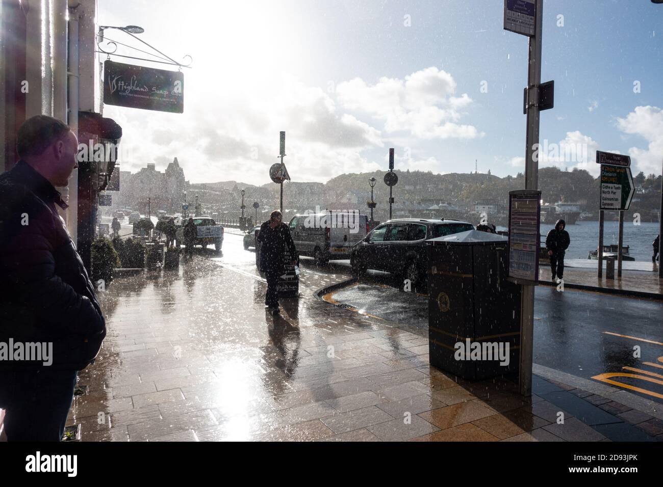 Oban high street during a heavy autumn shower while still sunny Stock Photo