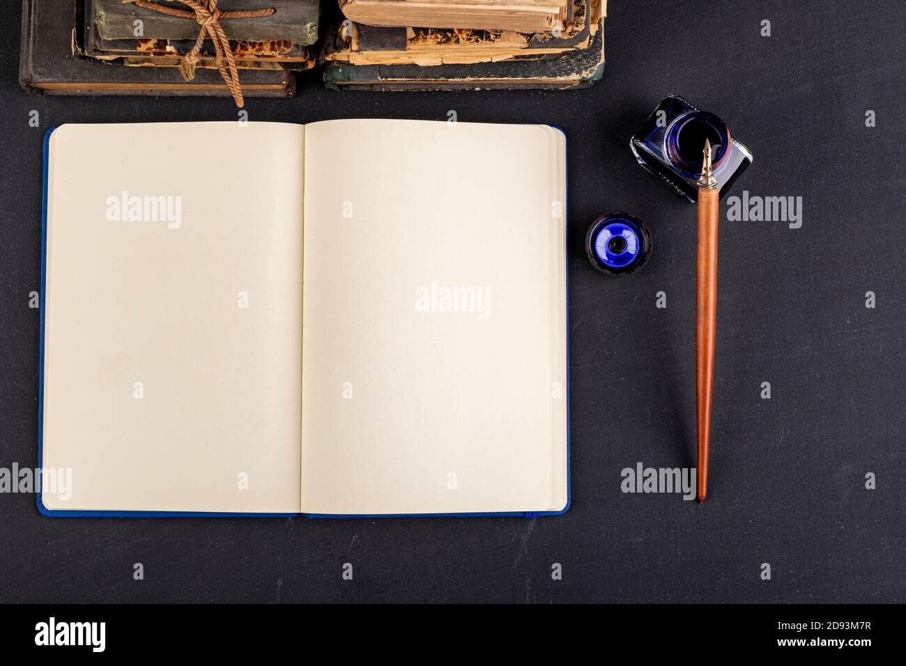 Blank notebook, ink and old books. Old writer's workplace. Dark ...