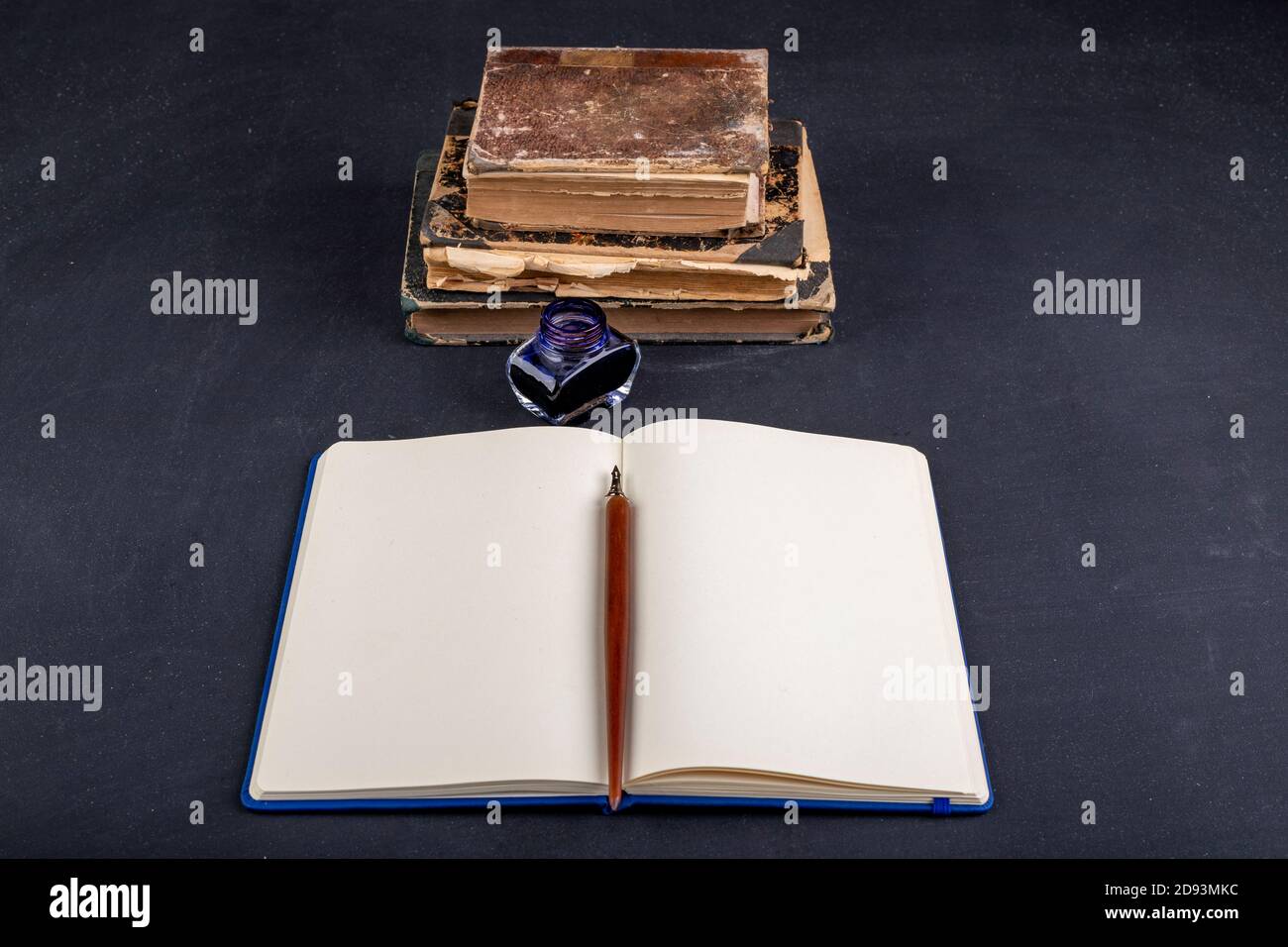 Blank notebook, ink and old books. Old writer's workplace. Dark ...