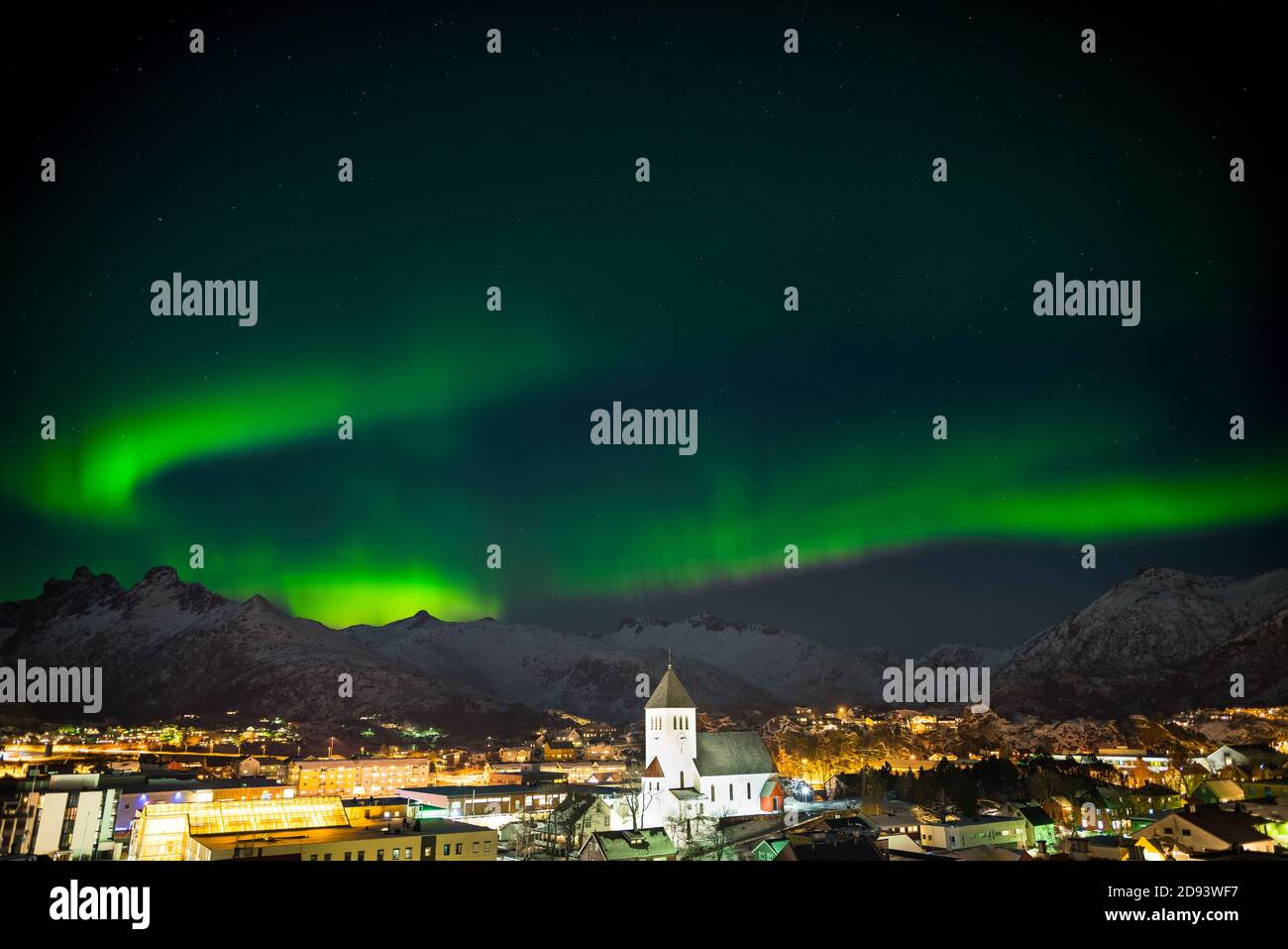 Dancing green polar lights over the town Svolvaer on the Lofoten islands in Norway at night in winter with snow Stock Photo