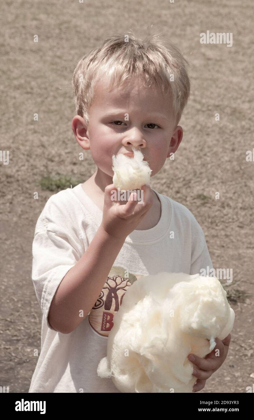 A young boy enjoys eating cotton candy at the county fair. Photo by Liz