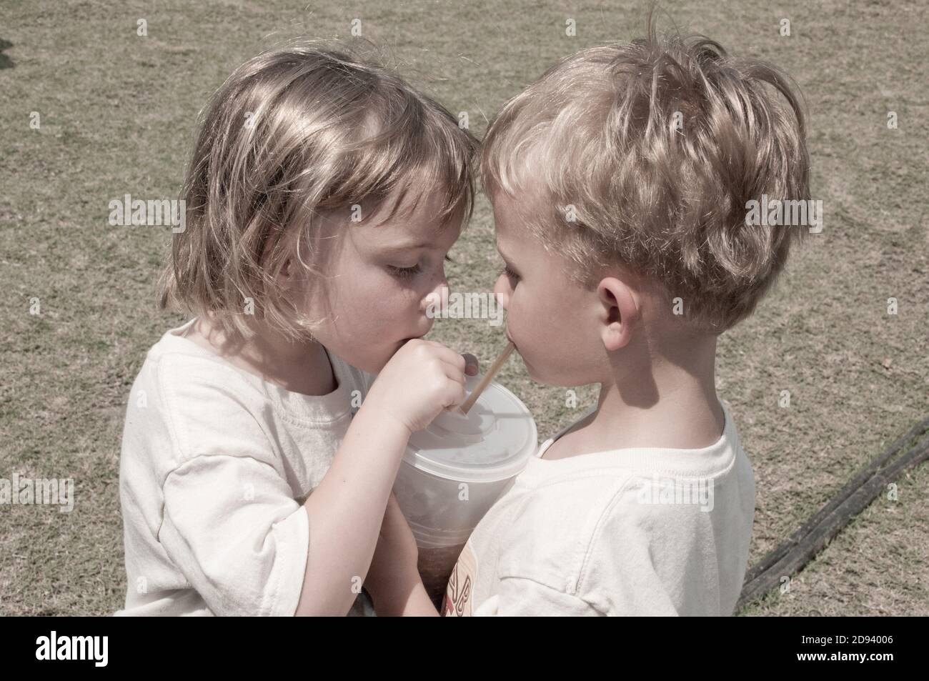 Twins share a drink at the county fair. Photo by Liz Roll Stock Photo
