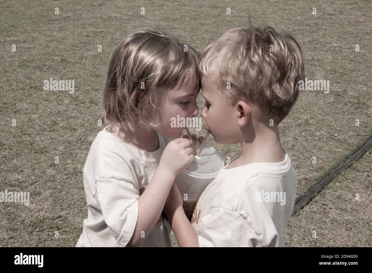 Twins share a drink at the county fair. Photo by Liz Roll Stock Photo