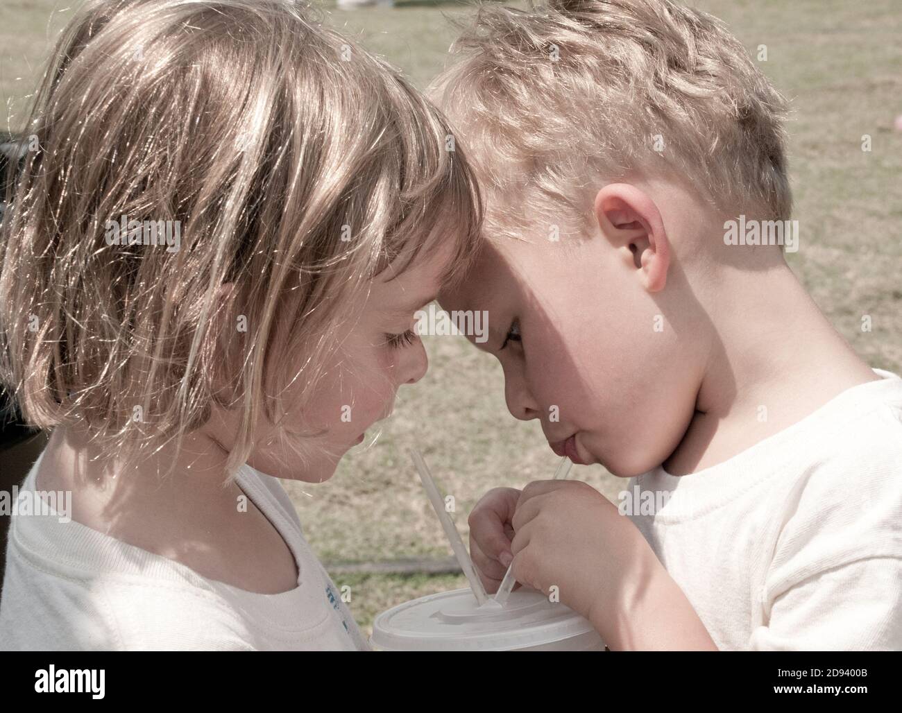 Twins share a drink at the county fair. Photo by Liz Roll Stock Photo