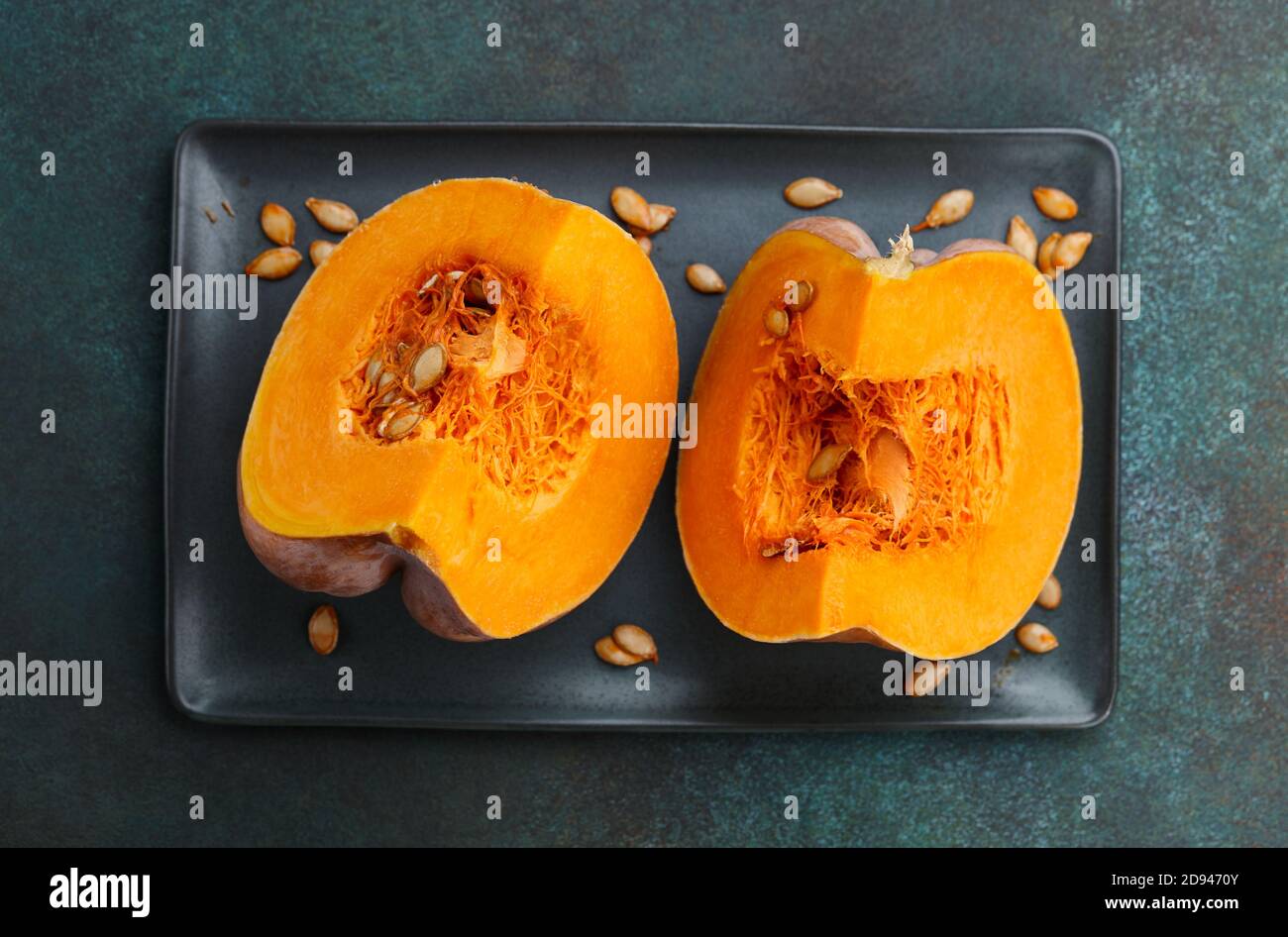 Pumpkin slices in plate on textured green background. Seasonal food. Stock Photo