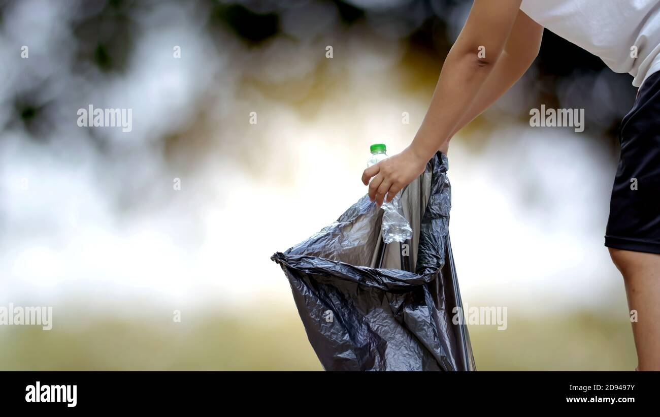 Close-up of hand-picked plastic bottle collectors or clear recycled waste in black garbage bags and a natural background give the idea of the environment Stock Photo