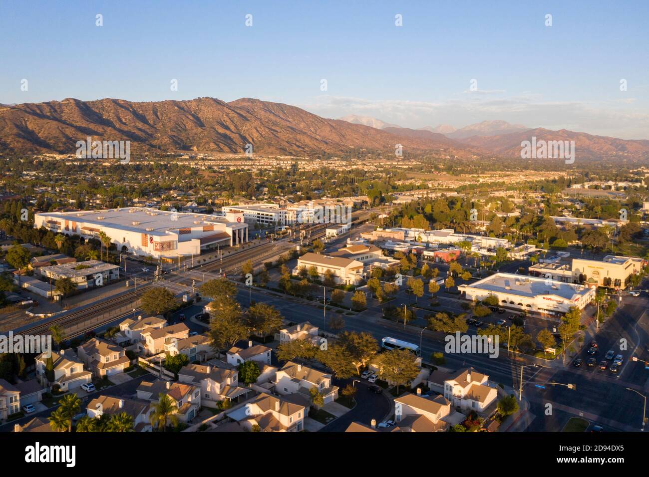 Evening aerial views over downtown Azusa, California and the San Gabriel Mountains at sunset Stock Photo