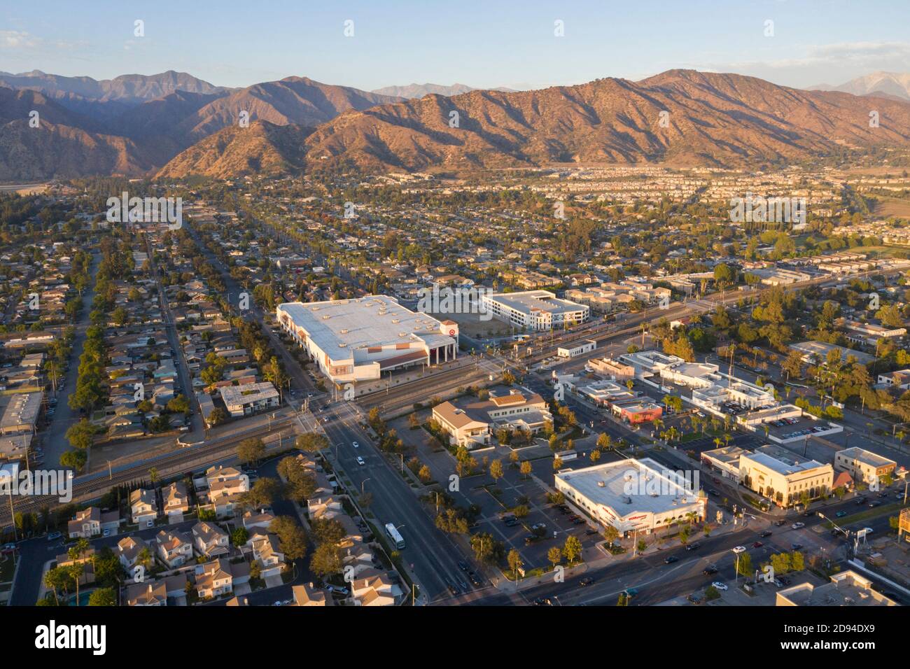 Evening aerial views over downtown Azusa, California and the San Gabriel Mountains at sunset Stock Photo