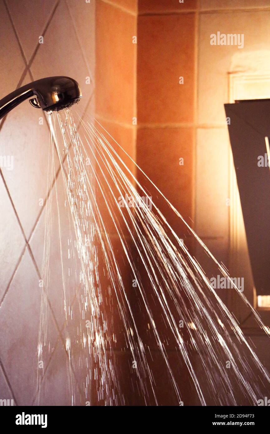 Water flowing from shower faucet in the bathroom Close up Stock Photo