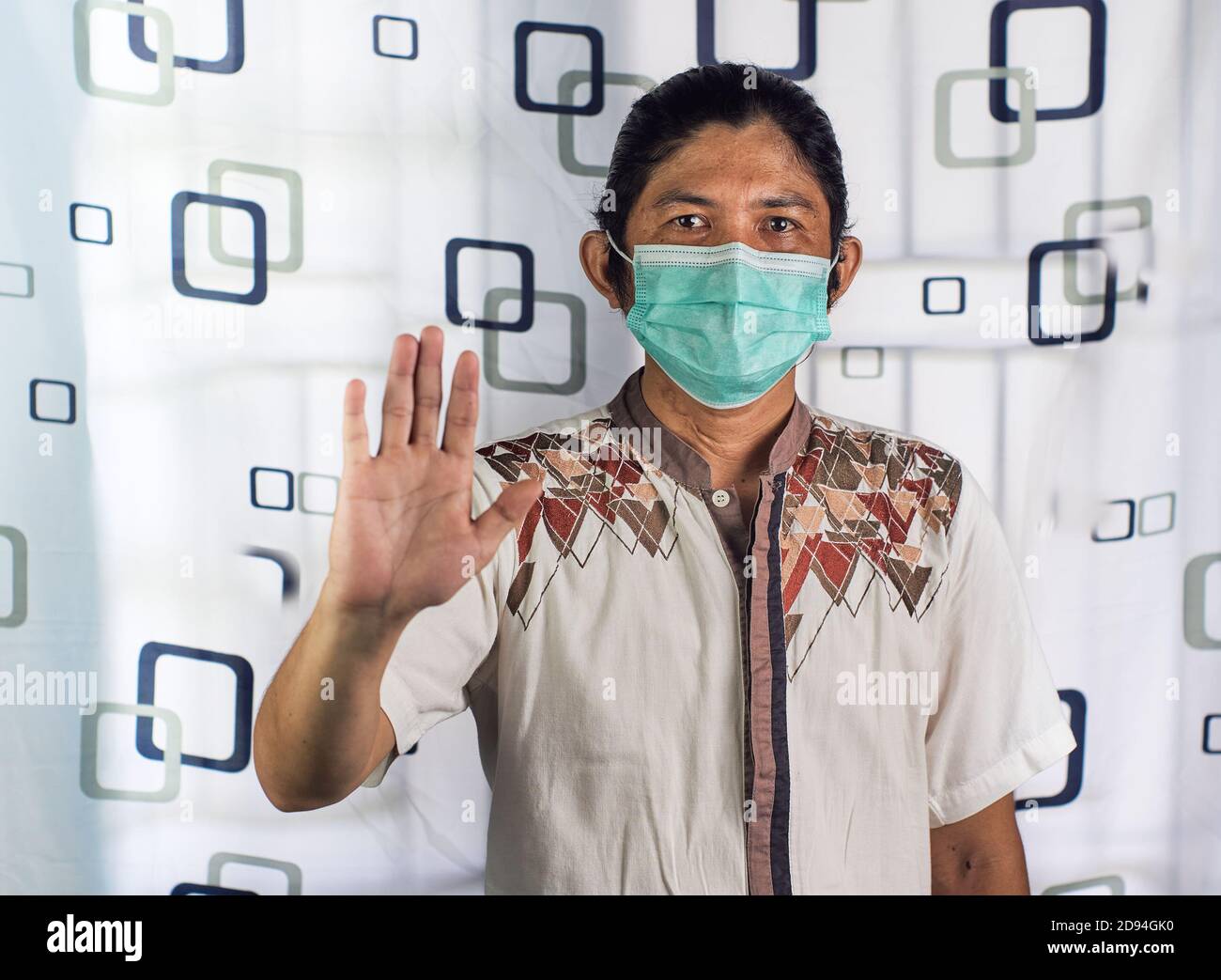 Potrait of asian man showing gesture stop. Asian man wearing surgical mask to protect against contracting viruses and protecting from any pollutions Stock Photo