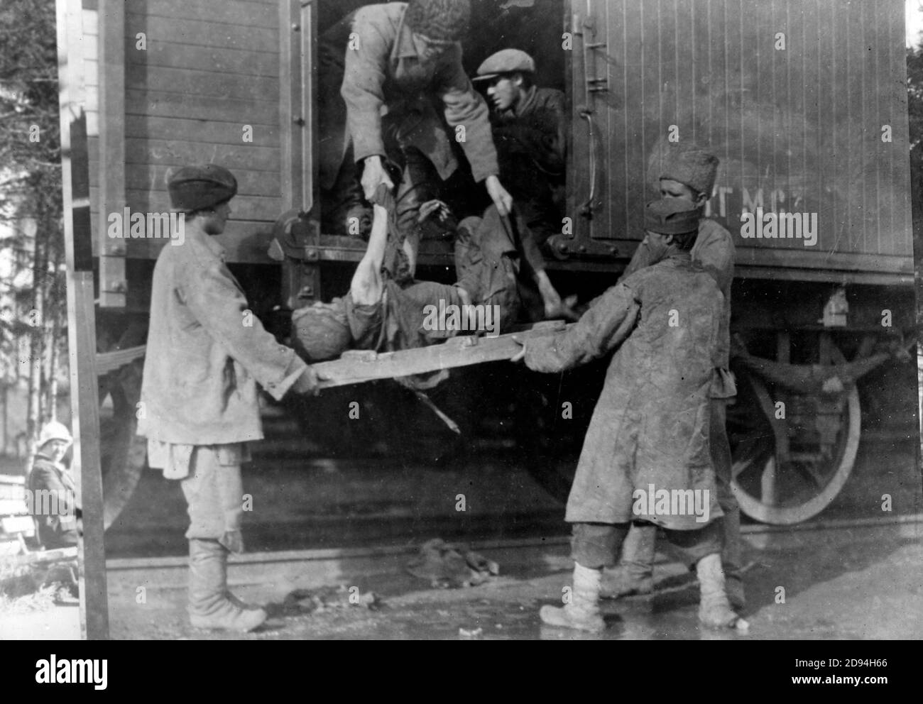 Ravages of typhus fever. This man is being taken dead from a railway train - December 1919 Stock Photo