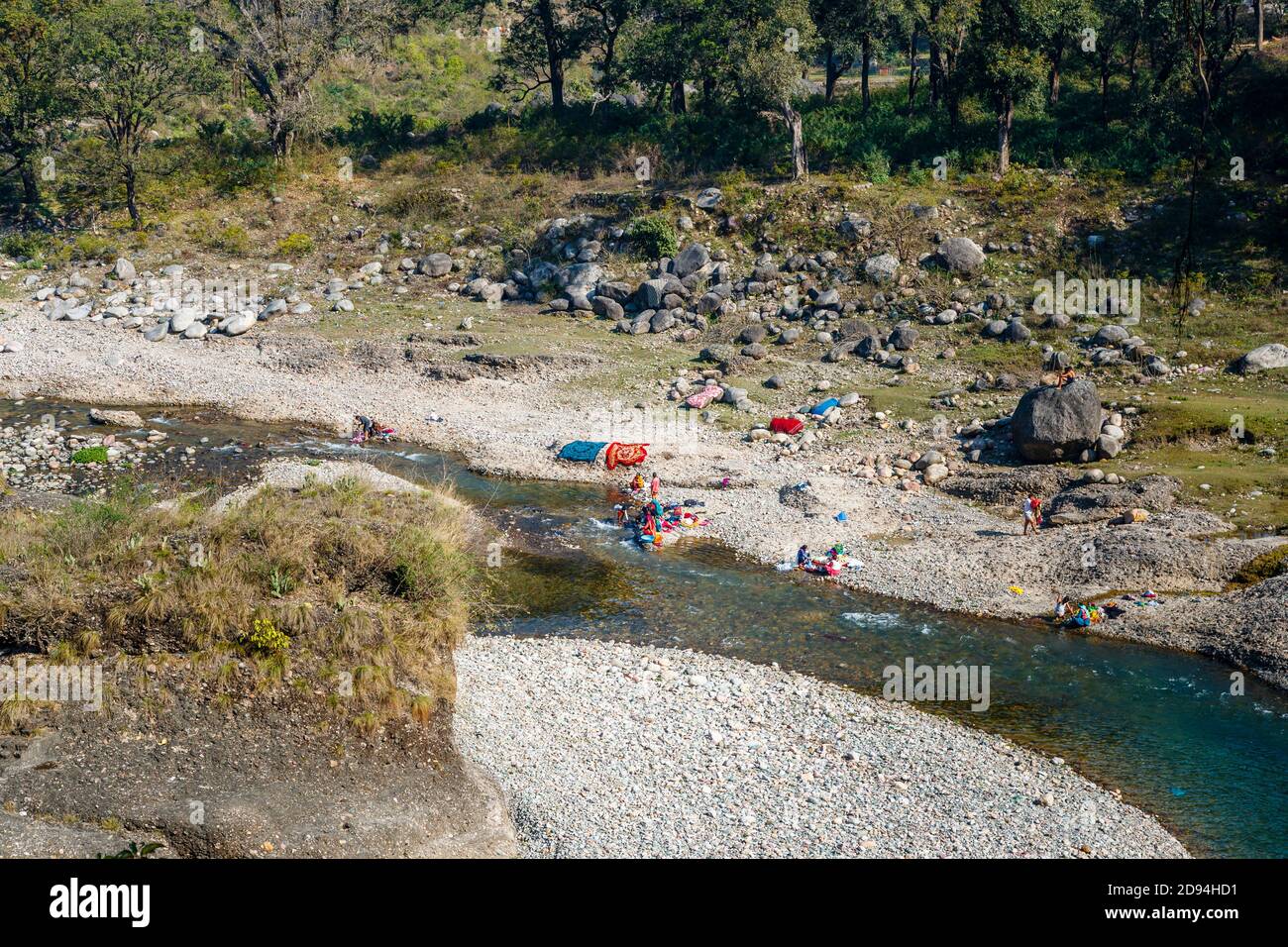 Gorge with local people washing and drying clothes on the side of a river in Kaswara, near Old Kangra and Kangra Fort in Himachal Pradesh, north India Stock Photo