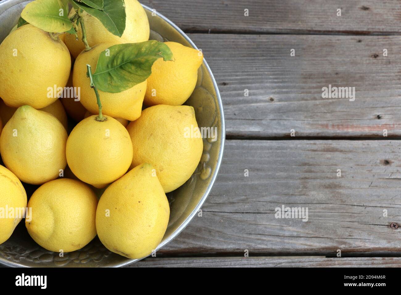 Silver bowl of beautiful, bright yellow lemons, homegrown in California