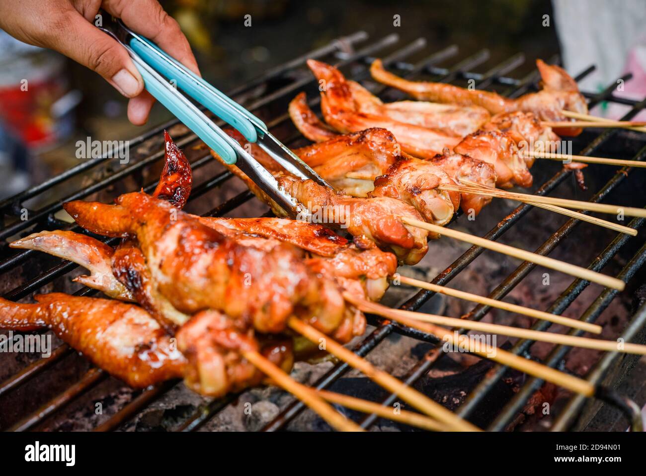 Chicken on the bbq getting turned and grilled Stock Photo Alamy