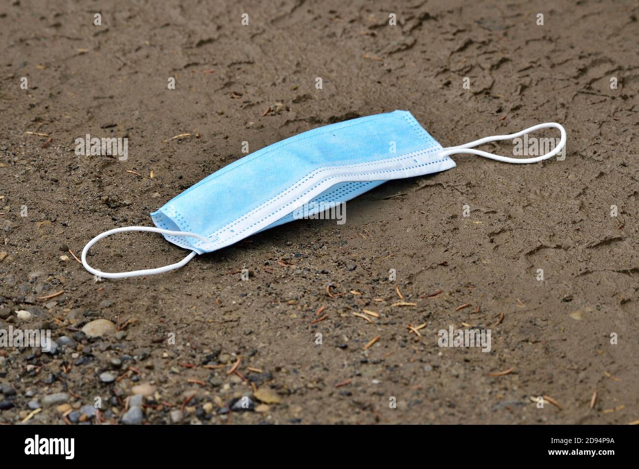 A discarded face mask used to protect a person from the Covid 19 virus then lost or thrown away Stock Photo